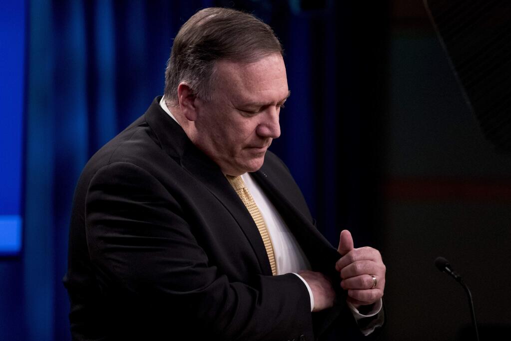 Secretary of State Mike Pompeo reaches for a pen during a news conference at the State Department in Washington, Monday, Nov. 18, 2019. Pompeo announced that the U.S. is softening its position on Israeli settlements in the West Bank, the latest in a series of Trump administration moves that weaken Palestinian claims to statehood. (AP Photo/Andrew Harnik)