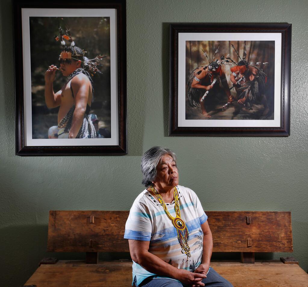 Tribal elder Priscilla Hunter of the Coyote Valley band of Pomo Indians stands in front of pictures of her nephews dancing in tribal ceremonies, at the Coyote Valley Reservation near Redwood Valley, California on Friday, October 28, 2016. (Alvin Jornada / The Press Democrat)