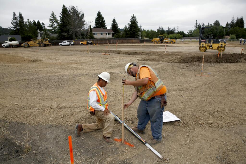 Mike Gayski, right, and Ricardo Espinoza, employees of Northwest General Engineering, set the grade as construction gets underway on a 30-unit apartment complex for low income farmworkers. Photo taken in Santa Rosa, on Tuesday, June 7, 2016. (BETH SCHLANKER/ The Press Democrat)