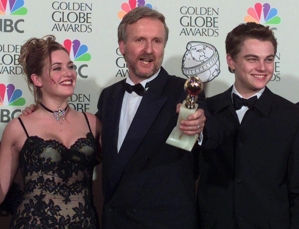 FILE - In this Jan. 18, 1998, file photo, Director James Cameron, center, poses with Kate Winslet and Leonardo DiCaprio after winning the awards for Best Dramatic Motion Picture and Best Director for the film 'Titanic' at the 55th Annual Golden Globe Awards in Beverly Hills, Calif. Twenty years after DiCaprio and Winslet fell in love on that doomed ship, “Titanic” is sailing back into theaters for one week. Dolby Laboratories, Paramount Pictures and AMC Theaters said Wednesday, Nov. 15, 2017, that the Cameron film will be shown in re-mastered Dolby Vision at select AMC locations nationwide starting Dec. 1. (AP Photo/Mark J. Terrill, File)