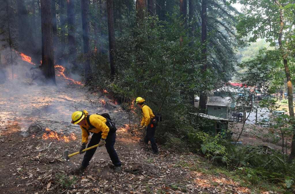 Culver City firefighters cut a line to protect a residence from advancing flames along Mill Creek Road near Healdsburg on Tuesday, Aug. 25, 2020.  (Christopher Chung/ The Press Democrat)