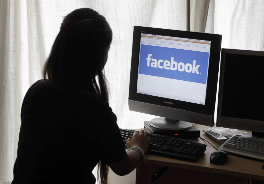 FILE - In this Monday, June 4, 2012, file photo, a girl looks at Facebook on her computer in Palo Alto, Calif. (AP Photo/Paul Sakuma, File)