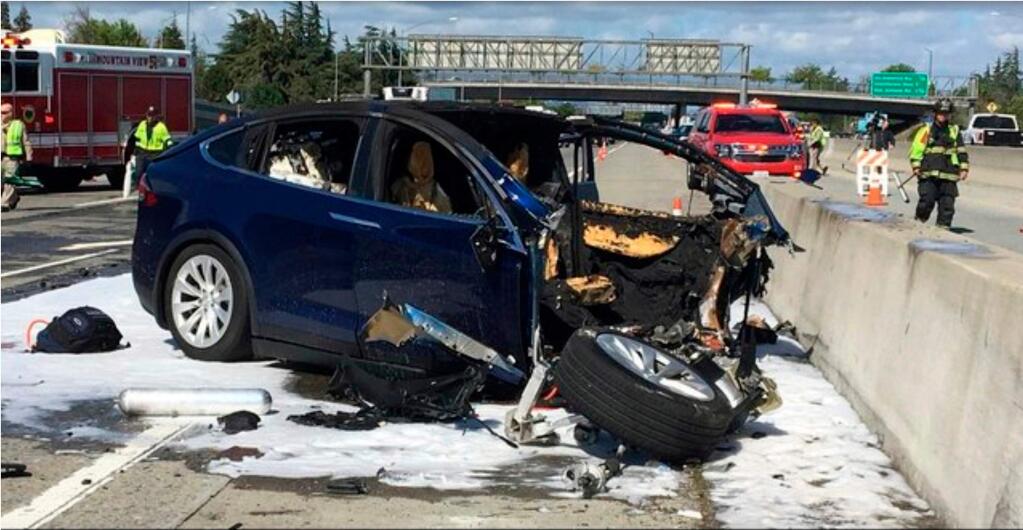 FILE - In this March 23, 2018, file photo provided by KTVU, emergency personnel work at the scene where a Tesla electric SUV crashed into a barrier on U.S. Highway 101 in Mountain View, Calif. (KTVU via AP, File)