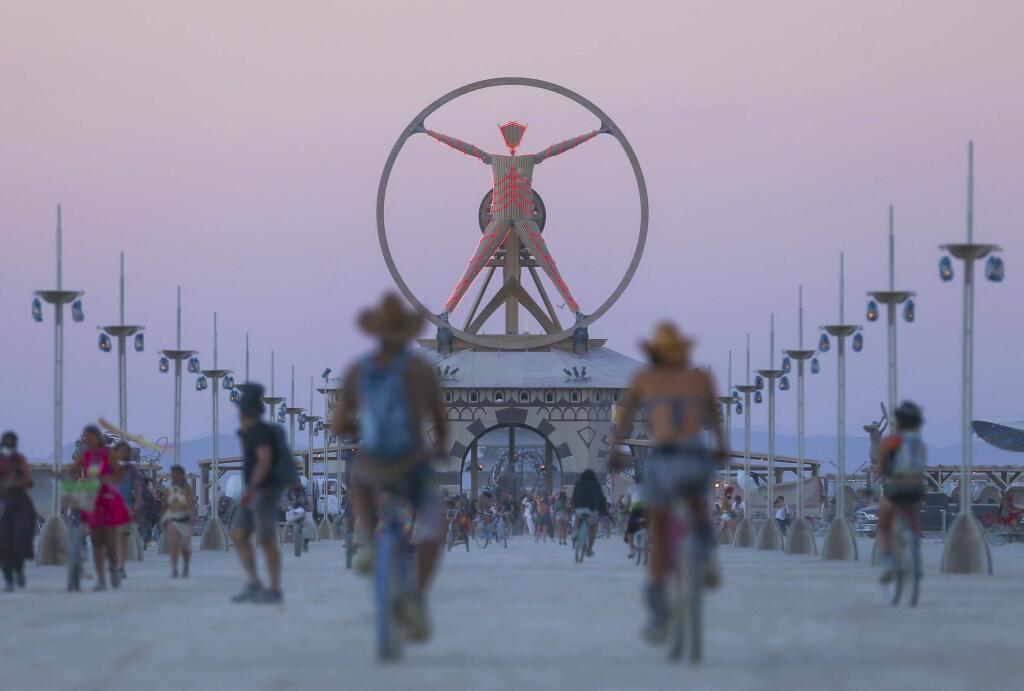 In this Wednesday, Aug. 31, 2016 photo, the Burning Man effigy, modeled after the Leonardo da Vinci's Vitruvian Man, stands above the playa during Burning Man at the Black Rock Desert north of Reno, Nev. (Chase Stevens/Las Vegas Review-Journal via AP)