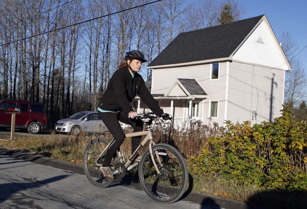 Nurse Kaci Hickox leaves her home on a rural road in Fort Kent, Maine, to take a bike ride with her boyfriend Ted Wilbur, Thursday, Oct. 30, 2014. The couple went on an hour-long ride followed by a Maine State Trooper. State officials are going to court to keep Hickox in quarantine for the remainder of the 21-day incubation period for Ebola that ends on Nov. 10. Police are monitoring her, but can't detain her without a court order signed by a judge. (AP Photo/Robert F. Bukaty)