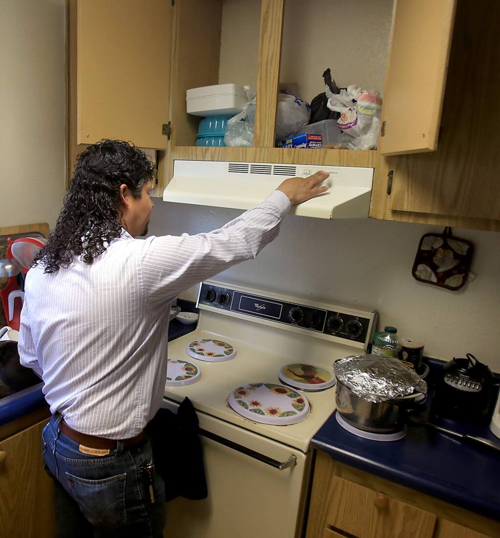Armando Perez of Santa Rosa shows the absence of a outlet for an oven fan at the Walnut Creek Apartments in August of 2015. (Kent Porter / Press Democrat) 2016