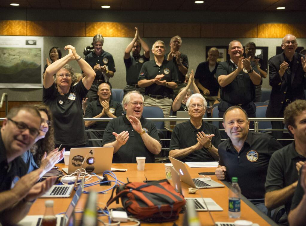 Members of the New Horizons science team react to seeing the spacecraft's last and sharpest image of Pluto before closest approach later in the day, Tuesday, July 14, 2015, at the Johns Hopkins University Applied Physics Laboratory (APL) in Laurel, Maryland. NASA's New Horizons spacecraft was on track to zoom within 7,800 miles (12,500 kilometers) of Pluto on Tuesday. (Bill Ingalls/NASA via AP)