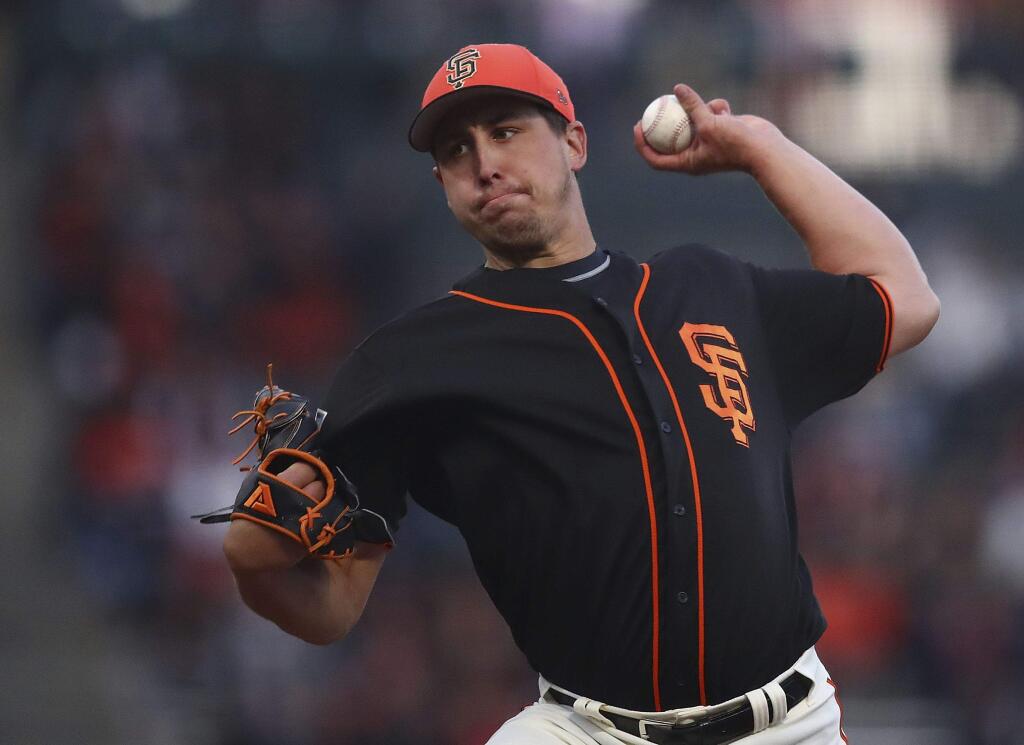 The San Francisco Giants' Derek Holland works against the Oakland Athletics during the first inning of a spring training game on Monday, March 26, 2018, in San Francisco. (AP Photo/Ben Margot)