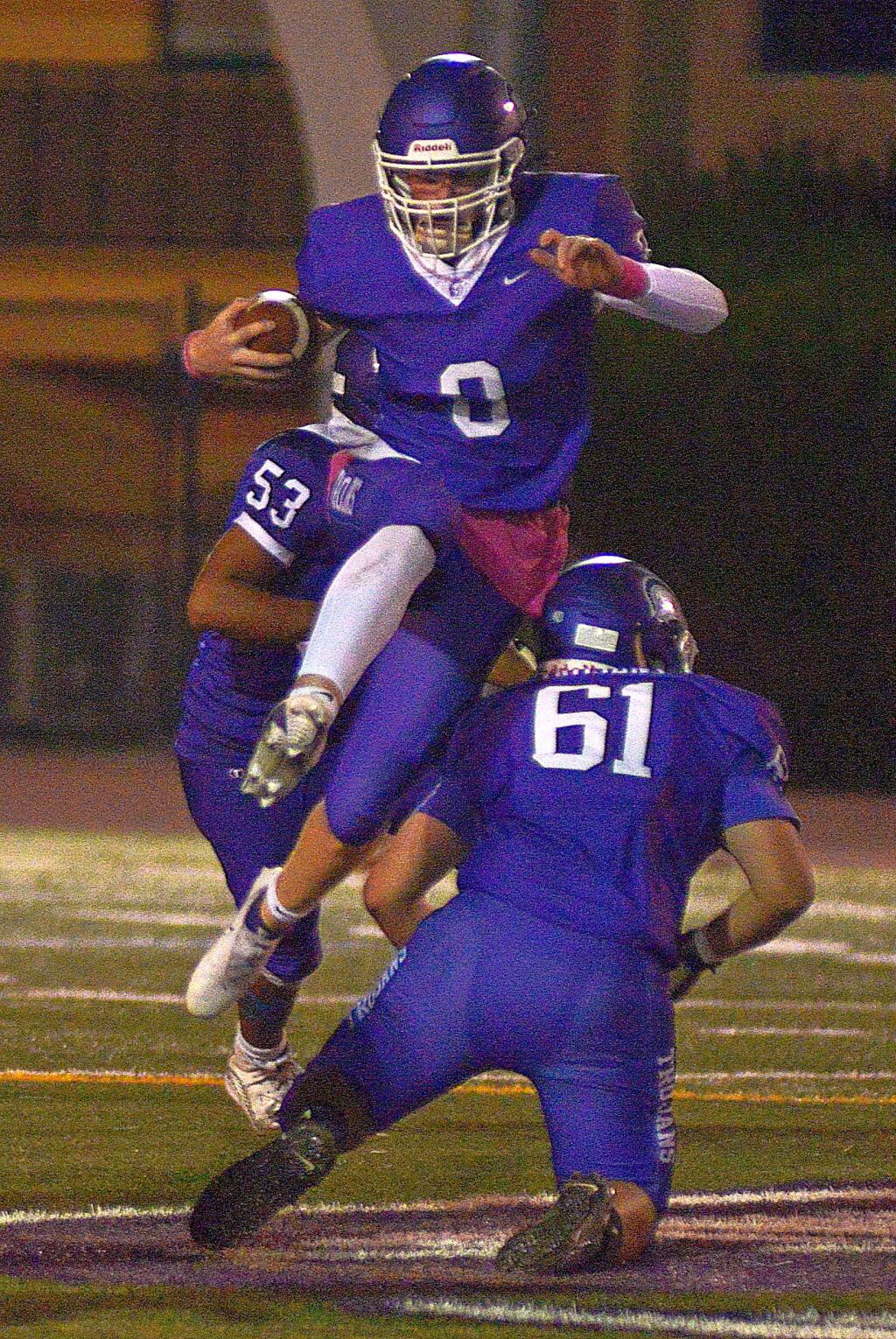 Petaluma's Henry Ellis flies by blockers Tyshaun Thames and Jagger Williams. (SUMNER FOWLER / FOR THE ARGUS- COURIER)