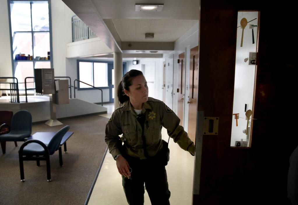 Deputy A. Reeves opens doors for lunch delivery in the R.E.A.C.T unit at Sonoma County's Main Adult Detention Facility at in Santa Rosa, on Tuesday, April 14, 2015. (BETH SCHLANKER/ The Press Democrat)