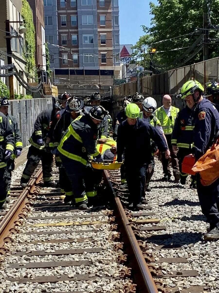 This photo provided by the Boston Fire Department, Firefighters and EMT personnel carry an injured person after a train car derailed in Boston on Saturday, June 8, 2019. Officials with the Massachusetts Bay Transportation Authority said the accident occurred at about 11 a.m. Saturday when a Green Line subway car derailed in a tunnel near Kenmore Square. Officials said several people were injured but none of the injuries are life-threatening. The cause of the derailment is under investigation. (Boston Fire Dept. via AP)