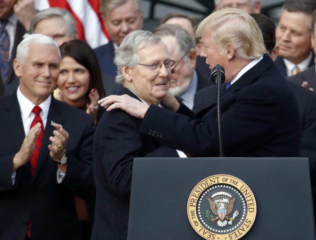 President Donald Trump introduces Senate Majority Leader Sen. Mitch McConnell of Ky., during a bill passage event on the South Lawn of the White House in Washington, Wednesday, Dec. 20, 2017, to acknowledge the final passage of tax cut legislation by Congress. Vice President Mike Pence watches at left,(AP Photo/Carolyn Kaster)
