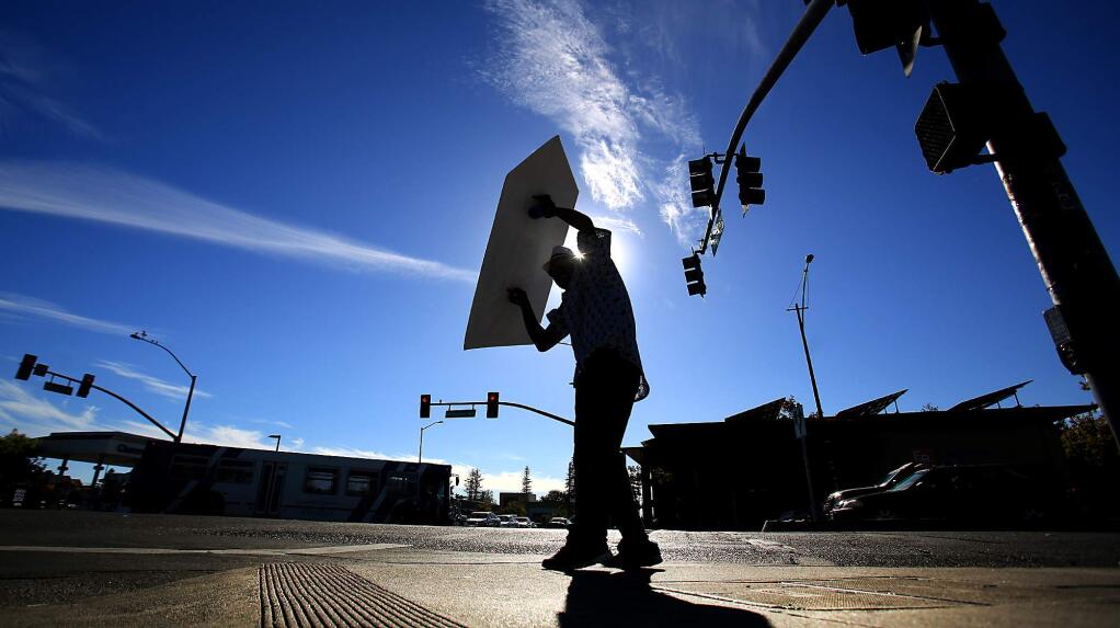 Battling it out with the hot sun at Steele Lane and Mendocino Ave., O.G. twirls a sign for Canevari's Delicatessen & Catering in Santa Rosa, Friday Sept. 23, 2016. (Kent Porter / The Press Democrat)