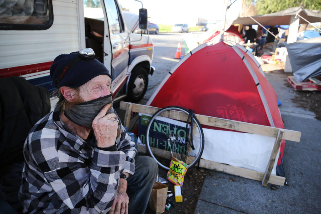 William Barham, who has been homeless for 9 years, sits outside his friend's RV at the homeless encampment on Industrial Dr. in Santa Rosa, Calif., on Monday, January 18, 2021. (BETH SCHLANKER/ The Press Democrat)