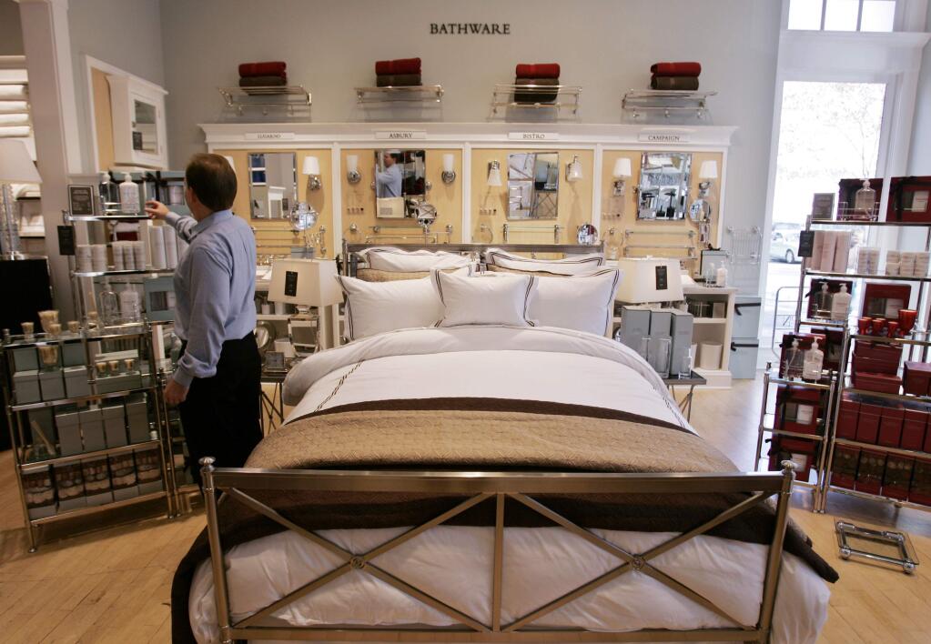 A customer looks at items at a Restoration Hardware store in Palo Alto, Calif., Monday, Nov. 26, 2007. Sears Holdings Corp. said Monday it was prepared to buy out the rest of retro-themed retailer Restoration Hardware Inc. for a nickel-per-share premium over a competing offer, a move that could help the iconic chain spruce up its merchandise lines. (AP Photo/Paul Sakuma)