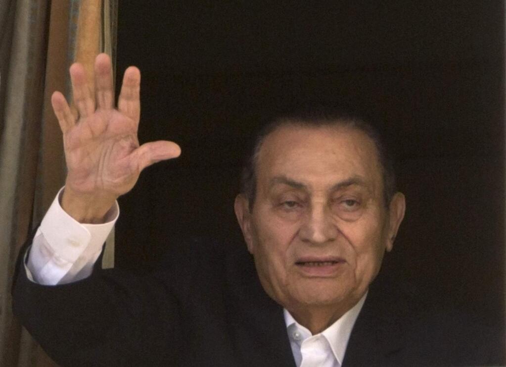 FILE - In this Monday, April 25, 2016 file photo, ousted Egyptian President Hosni Mubarak waves to his supporters from his room at the Maadi Military Hospital in Cairo, Egypt. Mubarak returned home on Friday, Match 24, 2017, free following his release from custody after legal proceedings that took years since his 2011 ouster - years during which the country witnessed major upheavals and rights activists saw their hopes scuttled that the autocrat would face justice for the deaths of hundreds who defied his rule. (AP Photo/Amr Nabil, File)