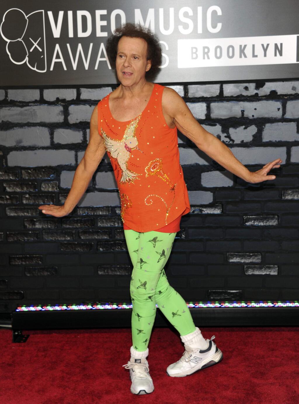 FILE - In this Aug. 25, 2013 file photo, Richard Simmons arrives at the MTV Video Music Awards in the Brooklyn borough of New York. Despite what seems to be a national obsession with the fitness guru's wellbeing, his publicist, manager, brother and two officers from the LAPD have all said the 68-year-old is at home in the Hollywood Hills and doing fine. (Photo by Evan Agostini/Invision/AP, File)