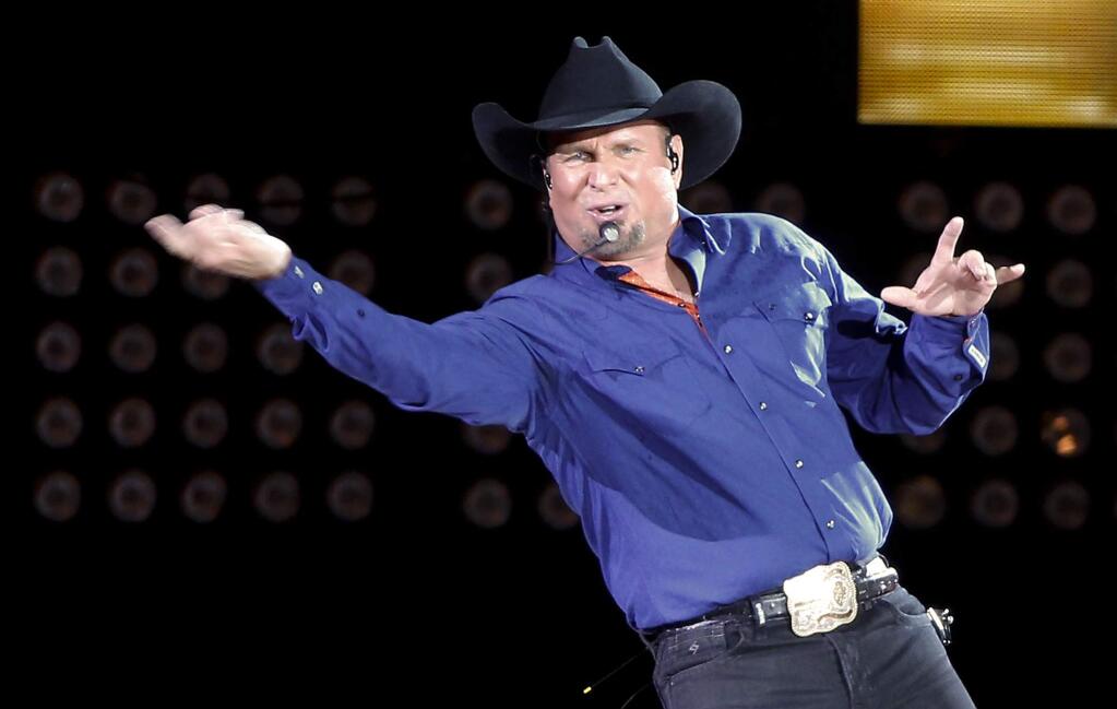 FILE - In this July 8, 2016, file photo, Garth Brooks sings 'Ain't Going Down' for his opening song during a performance at Yankee Stadium in New York. Brooks announced on Sept. 27, 2017, a five-part autobiography. The first book will be released in November. (AP Photo/Julie Jacobson, File)
