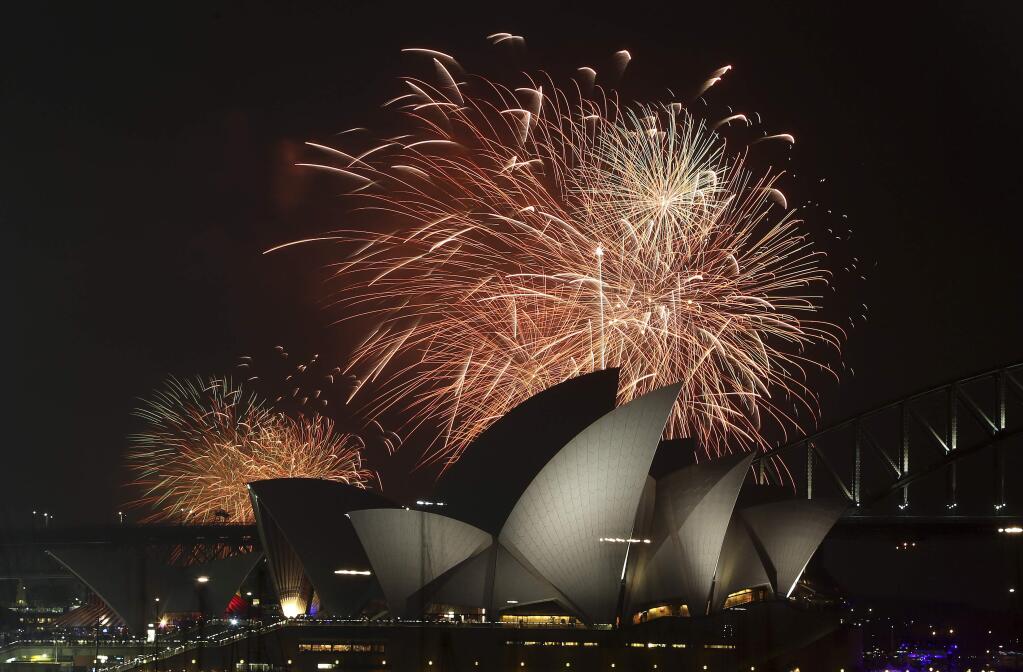 Fireworks explode over the Opera House and the Harbour Bridge during New Year's Eve celebrations in Sydney, Australia, Wednesday, Dec. 31, 2014. Thousands of people crammed into Lady Macquaries Chair to watch the annual fireworks show. (AP Photo/Rob Griffith)