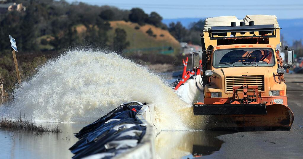 A Cal Trans driver blades water from last week's storms that inundated west bound Highway 37, Tuesday, Feb. 19, 2019 near Atherton, where construction crews placed K-rails, sandbags and black viscaline to stop the seepage on to the road. (Kent Porter / The Press Democrat) 2019