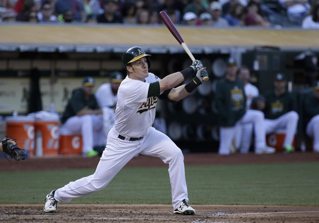 Oakland Athletics' Mark Canha hits a run-scoring single against the Seattle Mariners during the second inning of a game in Oakland Friday, July 3, 2015. (AP Photo/Jeff Chiu)