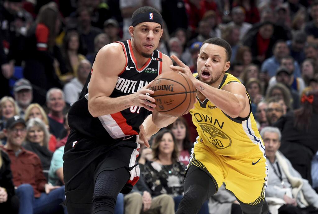 Portland Trail Blazers guard Seth Curry, left, drives to the basket on his brother, Golden State Warriors guard Stephen Curry, during the second half in Portland, Ore., Wednesday, Feb. 13, 2019. The Blazers won 129-107. (AP Photo/Steve Dykes)