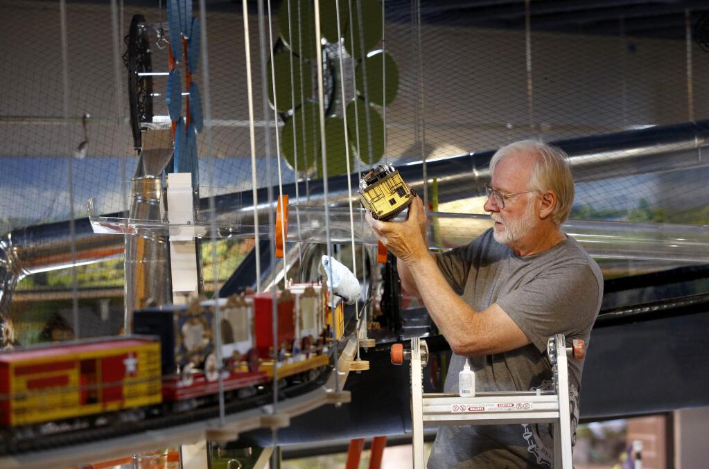 Jim Cunningham, a volunteer from the Redwood Empire Garden Railway Society, fine tunes one of the two overhead railroads at the Children's Museum of Sonoma County in Santa Rosa, on Tuesday, June 16, 2015. (BETH SCHLANKER/ The Press Democrat)
