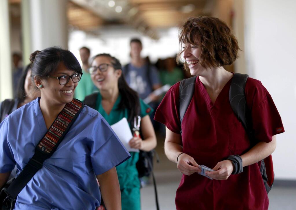 Kristina Rodriguez, right, a first-year medical student, walks to a lab portion of a Developmental, Gross and Radiographic Anatomy class with fellow student Camille Roque at UC-Davis School of Medicine in Sacramento, California on Tuesday, August 12, 2014. Rodriguez is a student in the new Accelerated Competency-based Education in Primary Care (ACE-PC) program. (BETH SCHLANKER/ The Press Democrat)