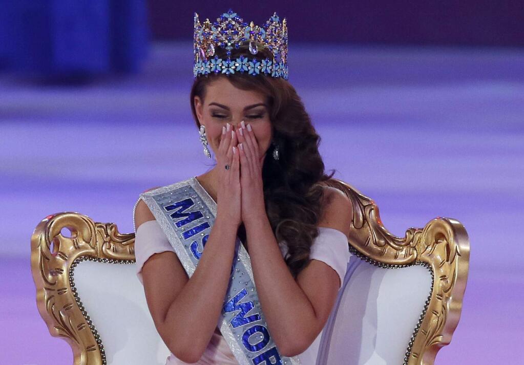 Miss South Africa Rolene Strauss gestures, after being crowned Miss World 2014 during the finale of the competition at the ExCel centre in London, Sunday, Dec. 14, 2014. Miss Hungary Edina Kulcsar came second with Miss United States, Elizabeth Safrit finishing third. (AP Photo/Alastair Grant)
