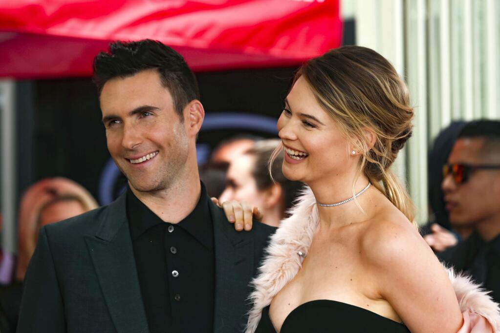 FILE - In this Feb. 10, 2017, file photo, Adam Levine, left, and his wife Behati Prinsloo smile at a ceremony that honored him with a Star on the Hollywood Walk of Fame in Los Angeles. Maroon 5 singer Levine spent his first Father's Day as a dad of two. Prinsloo shared a photo on Instagram of Levine holding their second daughter Gio Grace, who was born in February. (Photo by Willy Sanjuan/Invision/AP, File)