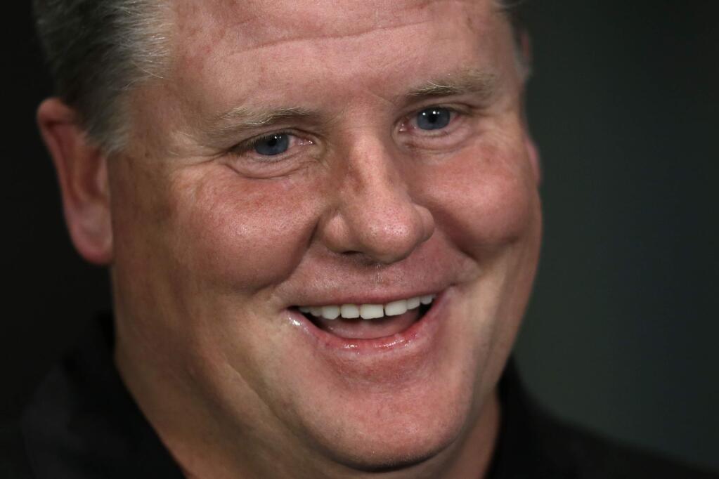 FILE - In this Jan. 17, 2013, file photo, Philadelphia Eagles new head coach Chip Kelly smiles during a television interview after a press conference at the team's NFL football training facility, in Philadelphia. Former Oregon coach Chip Kelly is joining ESPN as a studio analyst next season. ESPN announced Friday, May 26, 2017, it has signed Kelly to a multiyear deal. (AP Photo/Matt Rourke, File)