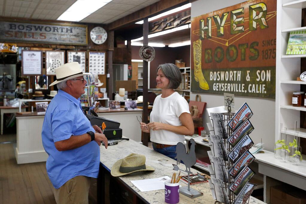 Richard Courtis of Thunder Bay, Ontario purchases a new Panama hat from Bosworth Store proprietor Gretchen Crebs, at the Bosworth Store, which functions as an apparel retail store, hat servicing shop, the town museum, as well as the business office for the Olive Hill Cemetery, in Geyserville, California, on Friday, August 17, 2018. (Alvin Jornada / The Press Democrat)