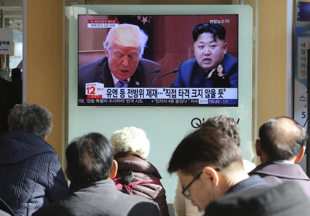 FILE- In this Nov. 21, 2017, file photo, people watch a TV screen showing images of U.S. President Donald Trump, left, and North Korean leader Kim Jong Un at Seoul Railway Station in Seoul, South Korea. With a sharp departure from years and sometimes decades of U.S. foreign policy, President Donald Trump has made a seismic global impact during his first year in office. Both North Korea and the U.S. traded threats and insults, and North Korea conducted an underground nuclear test and three ICBM launches that demonstrated at least a theoretical ability to reach the U.S. (AP Photo/Ahn Young-joon, File)