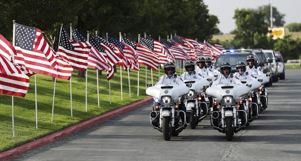 The funeral cortege for Battalion Chief Matt Burchett of the Draper Fire Department arrives at the Maverik Center in West Valley City, Utah, on Monday, Aug. 20, 2018. Battalion Chief Matt Burchett was hit by a tree Monday while fighting a wildfire north of San Francisco. He was flown to a hospital where he succumbed to his injuries. (Ravell Call/The Deseret News via AP)