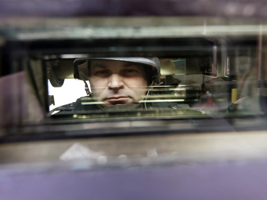 Sgt. Daniel D. Vogel of the Warrington Township, Pa. police department is seen through one of several periscopes on a M113 A2 armored personnel carrier aquired from the Defense Department though its surplus supplies program. (MATT ROURKE / Associated Press, 2007)