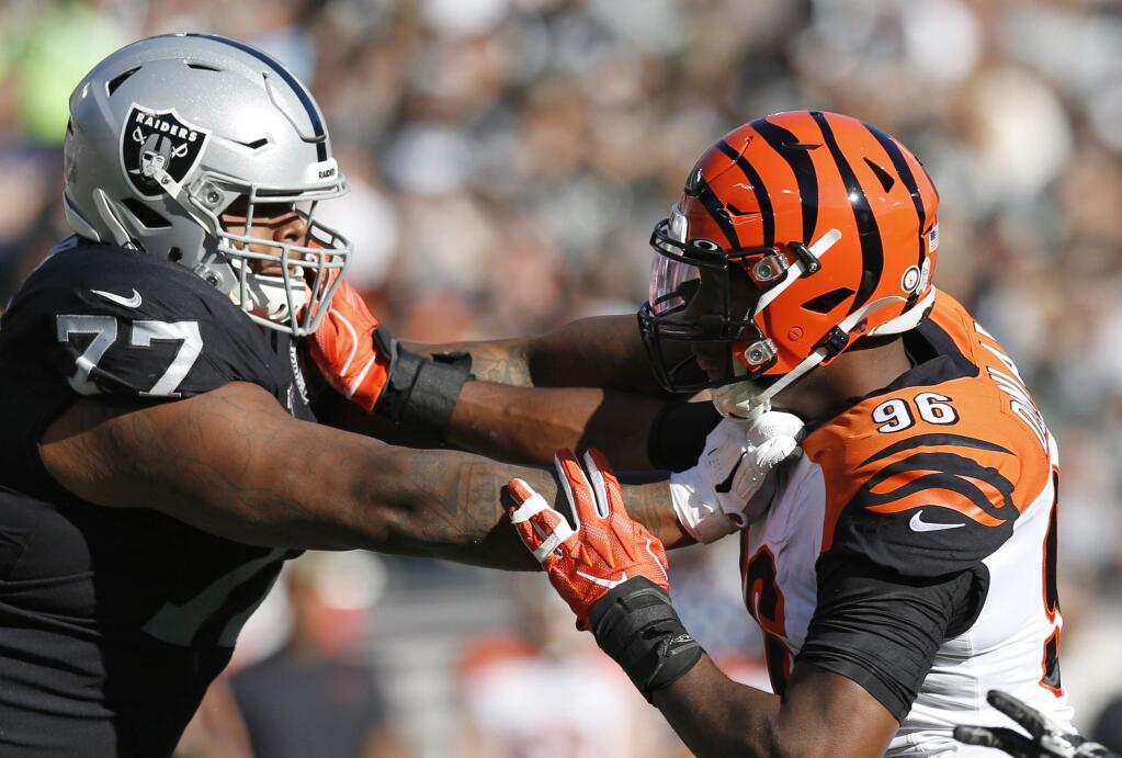 In this Nov. 17, 2019, file photo, Oakland Raiders offensive tackle Trent Brown, left, blocks Cincinnati Bengals defensive end Carlos Dunlap during the first half in Oakland. The Raiders placed Brown on season-ending injured reserve, one day after the big right tackle was named to his first Pro Bowl. (AP Photo/D. Ross Cameron, File)