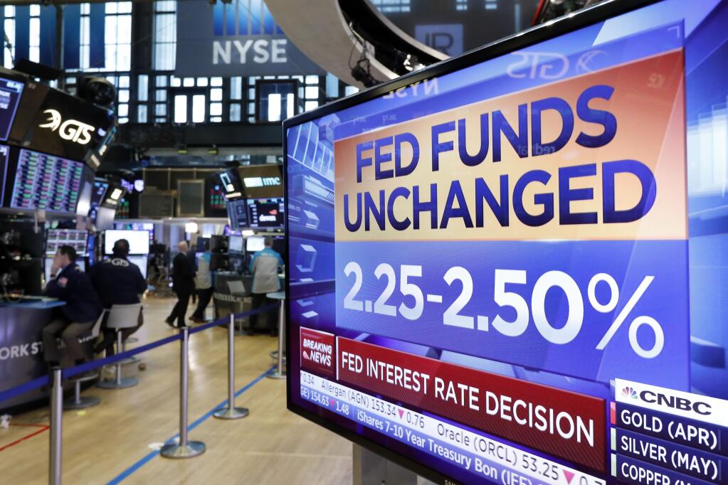 A screen on the floor of the New York Stock Exchange shows the rate decision of the Federal Reserve, Wednesday, March 20, 2019. The Federal Reserve is leaving its key interest rate unchanged and projecting no rate hikes in 2019, dramatically underscoring its plan to be 'patient' about any further increases. (AP Photo/Richard Drew)