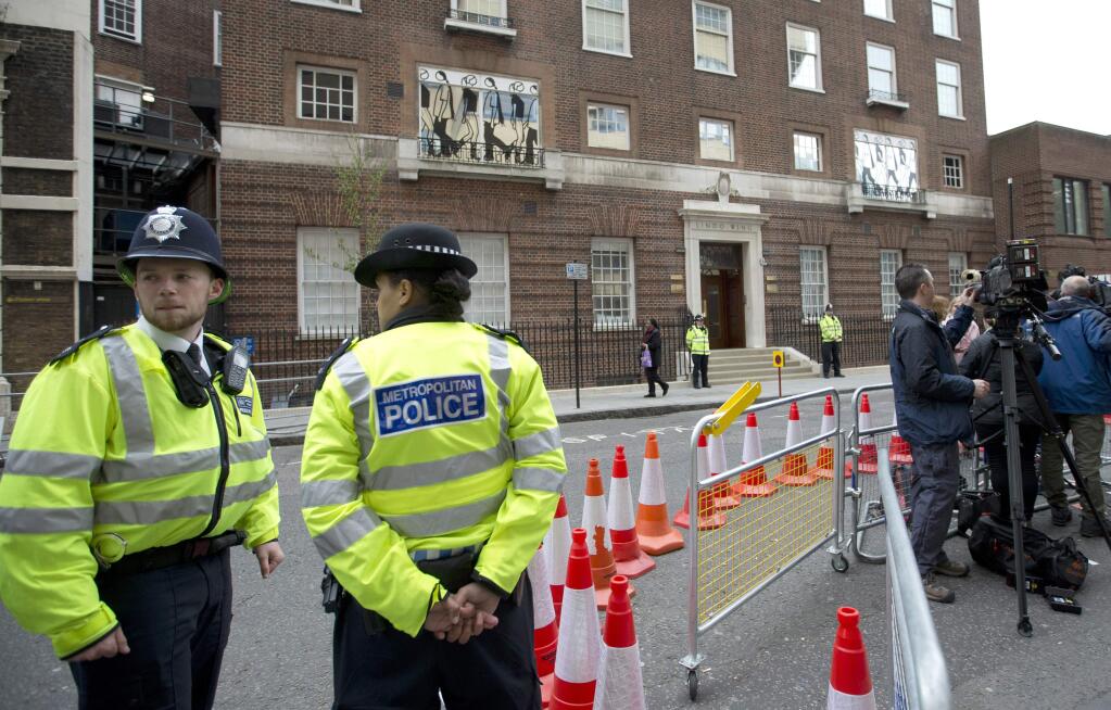 Police guard the front entrance to the Lindo Wing of St Mary's Hospital, and the media pens opposite as Kate, Duchess of Cambridge, has arrived and gone into labor to give birth to her second child in London, Saturday, May 2, 2015. (AP Photo/Alastair Grant)