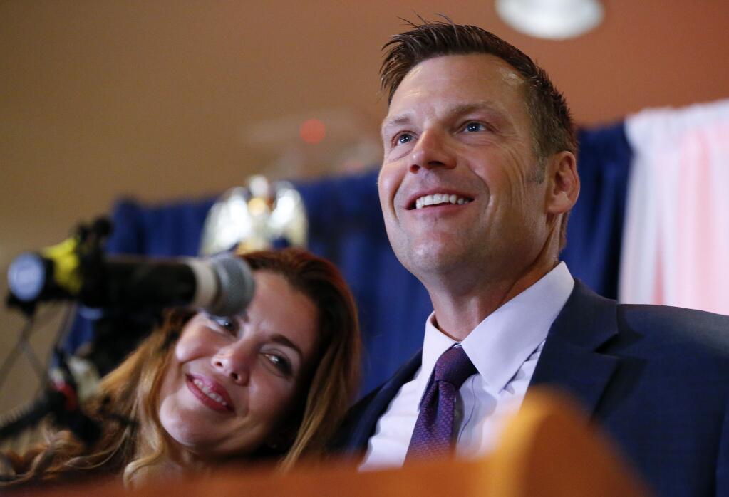 Kansas Republican gubernatorial candidate Kris Kobach and his wife Heather take the stage to thank their supporters and send them home for the night after problems with polls in Johnson County, Kan., delayed the final results until the early morning on Wednesday, Aug. 8, 2018, at the Capitol Plaza Hotel in Topeka, Kan. (Chris Neal/The Topeka Capital-Journal via AP)