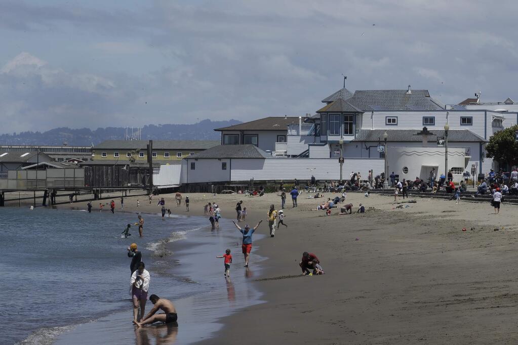 People visit the beach at Aquatic Park Cove during the coronavirus outbreak in San Francisco, Sunday, May 17, 2020. (AP Photo/Jeff Chiu)