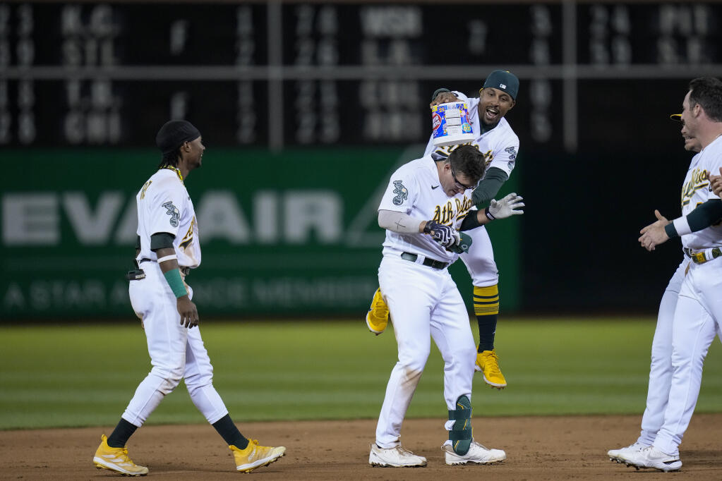 Oakland Athletics' Jonah Bride, center, celebrates with teammates after reaching first on a groundr with the bases loaded during the ninth inning of the team's baseball game against the Atlanta Braves in Oakland, Calif., Tuesday, May 30, 2023. Ramón Laureano scored from third on a fielding error by Braves third baseman Austin Riley. The Athletics won 2-1. (AP Photo/Godofredo A. Vásquez)