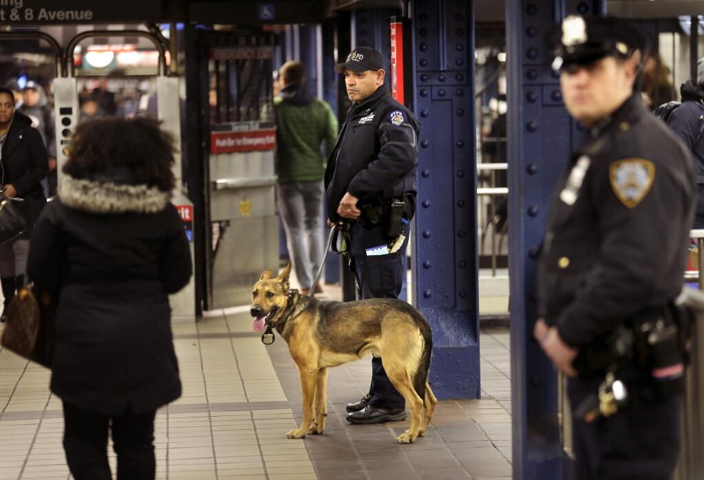 Police officers patrol in the passageway connecting New York City's Port Authority bus terminal and the Times Square subway station Tuesday, Dec. 12, 2017, near the site of Monday's explosion. Commuters returning to New York City's subway system on Tuesday were met with heightened security a day after a would-be suicide bomber's rush-hour blast in the heart of the New York City subway system failed to cause the bloodshed he intended. (AP Photo/Seth Wenig)