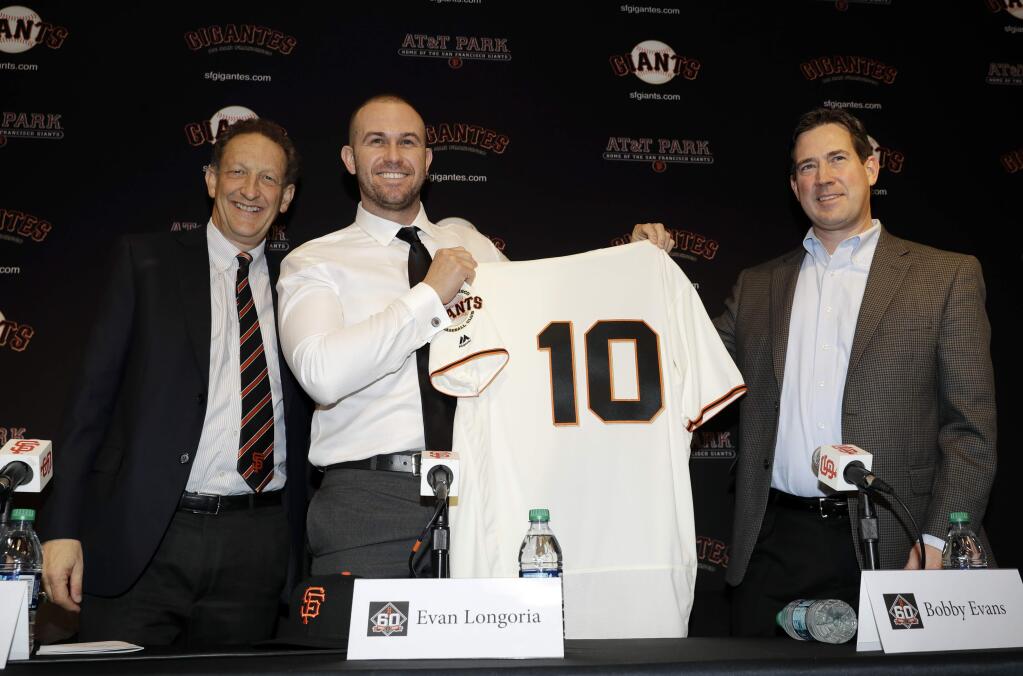 The San Francisco Giants' Evan Longoria, center, holds a jersey next to team CEO Larry Baer, left, and general manager Bobby Evans during an announcement on his recent trade to the team Friday, Jan. 19, 2018, in San Francisco.(AP Photo/Marcio Jose Sanchez)