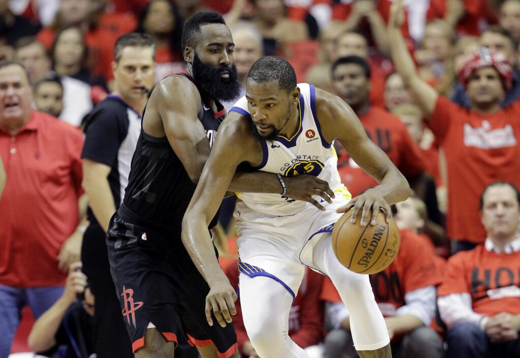 Golden State Warriors forward Kevin Durant, right, tries to work the ball past Houston Rockets guard James Harden during the second half in Game 2 of the NBA Western Conference final, Wednesday, May 16, 2018, in Houston. (AP Photo/David J. Phillip)