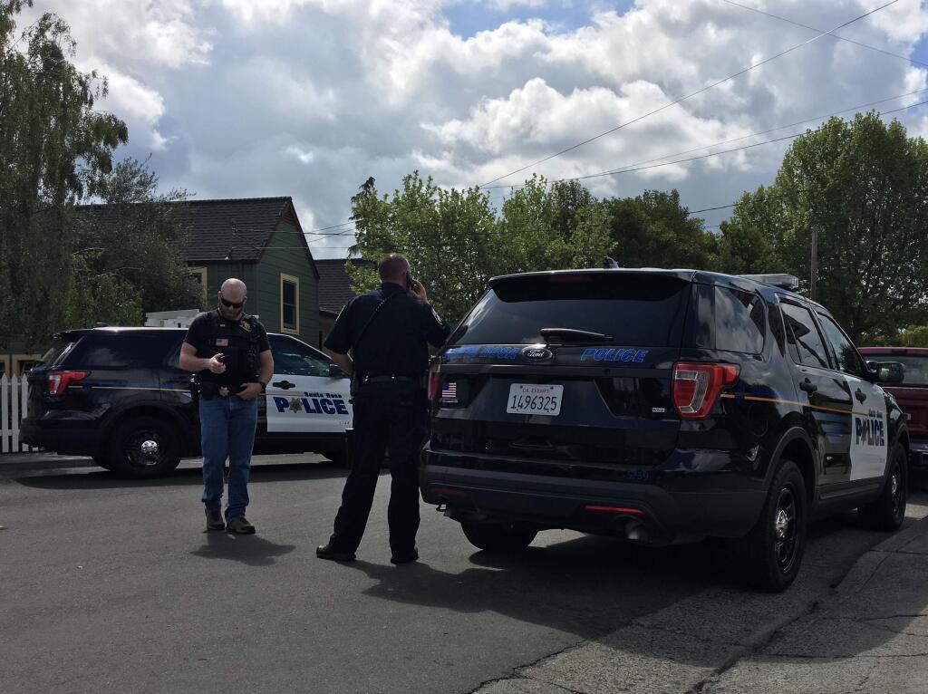 A Sonoma County Probation officer and a Santa Rosa police officer make calls after a probation compliance check of Brad James Adams turned into a 40-minute standoff on Friday, April 27, 2018. (NICK RAHAIM/ PD)