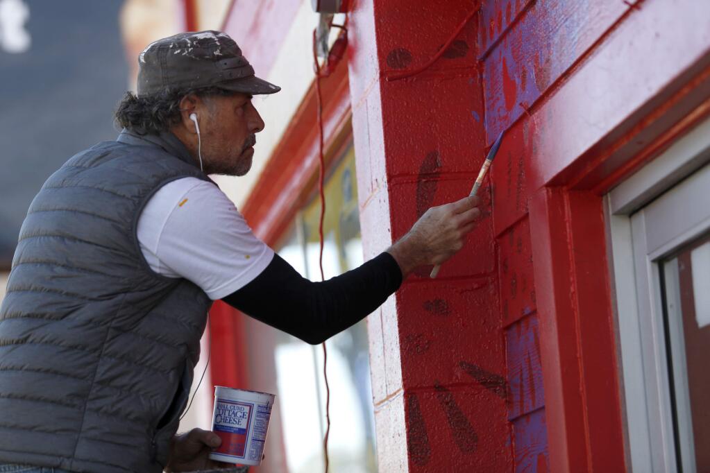 Artist Rico Martin paints the exterior of the El Brinquito market in Fetters Hot Springs.