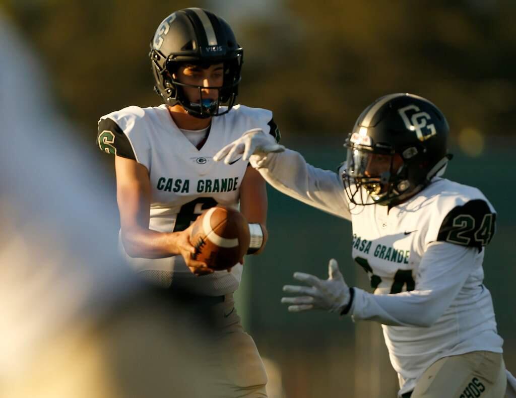 Casa Grande quarterback Miguel Robertson, left, hands the ball off to running back Julian Gaona during the first half against Montgomery high school in Santa Rosa on Friday, Aug. 30, 2019. (Alvin Jornada / The Press Democrat)