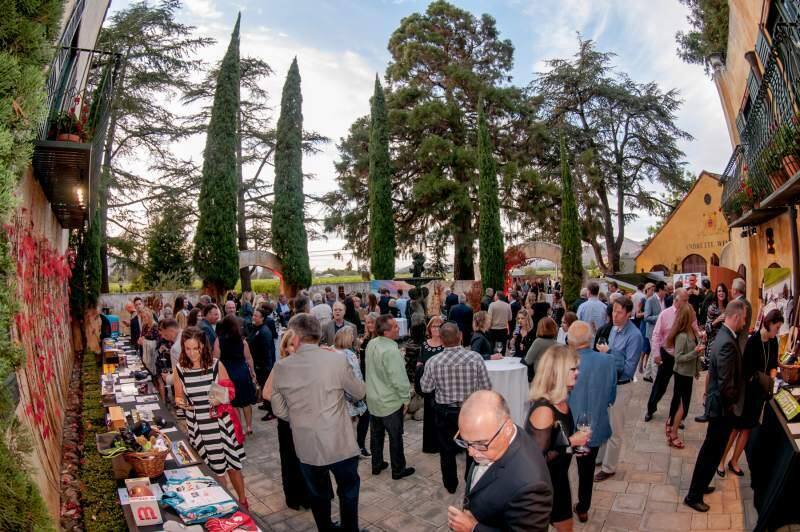 Speedway Children's Charities helped raise $76,000 during its IndyCar event this September. Above, attendees at the weekend's Andretti Winery fundraising dinner in Napa mull the silent auction items.