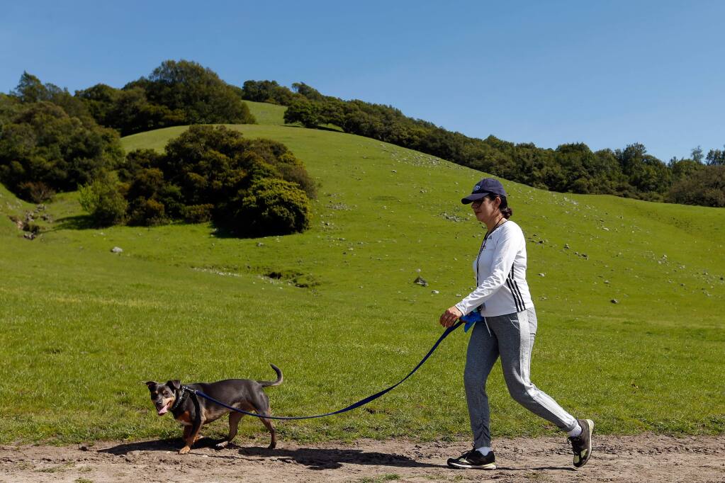 Maria Anguiano of Santa Rosa walks her dog Azul at Taylor Mountain Regional Park and Open Space Preserve in Santa Rosa, California on Wednesday, March 23, 2016. (Alvin Jornada / The Press Democrat