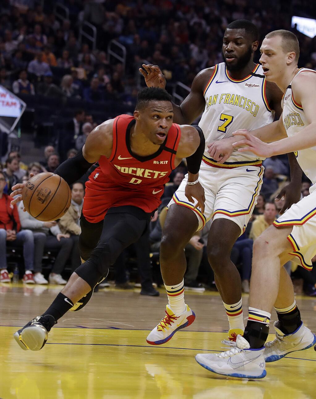 The Houston Rockets' Russell Westbrook, left, drives the ball against the Golden State Warriors' Eric Paschall (7) and Alen Smailagic, right, during the first half Thursday, Feb. 20, 2020, in San Francisco. (AP Photo/Ben Margot)